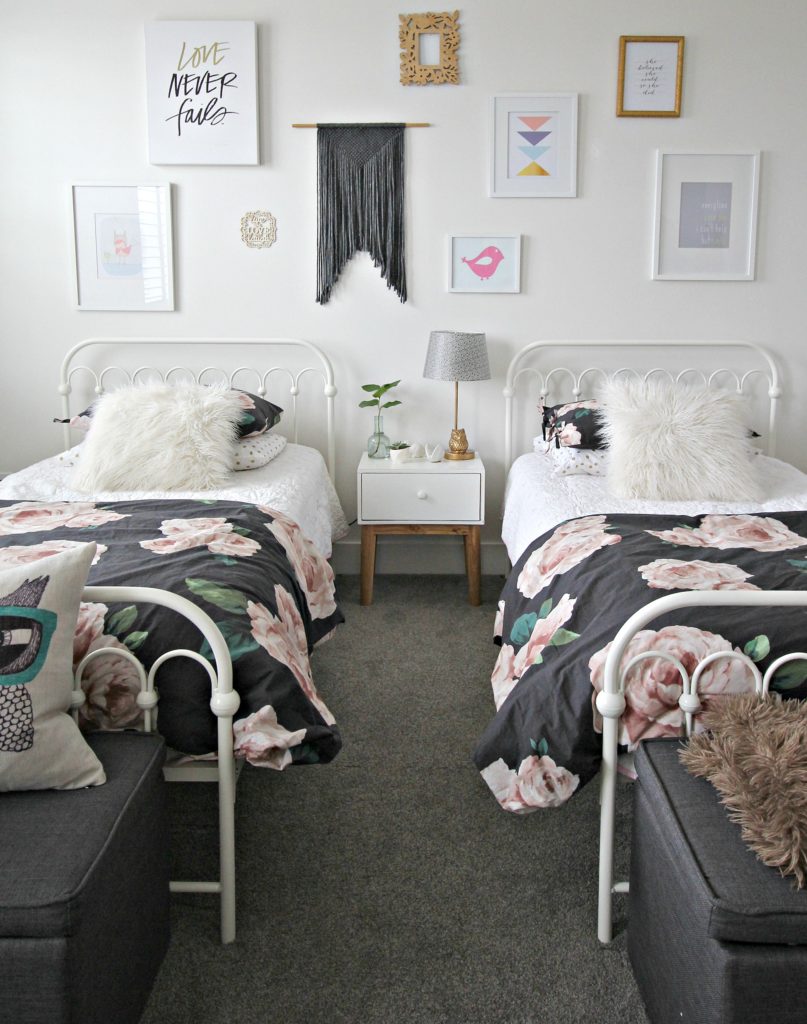 girl's bedroom with 2 beds, white walls, floral bedspreads