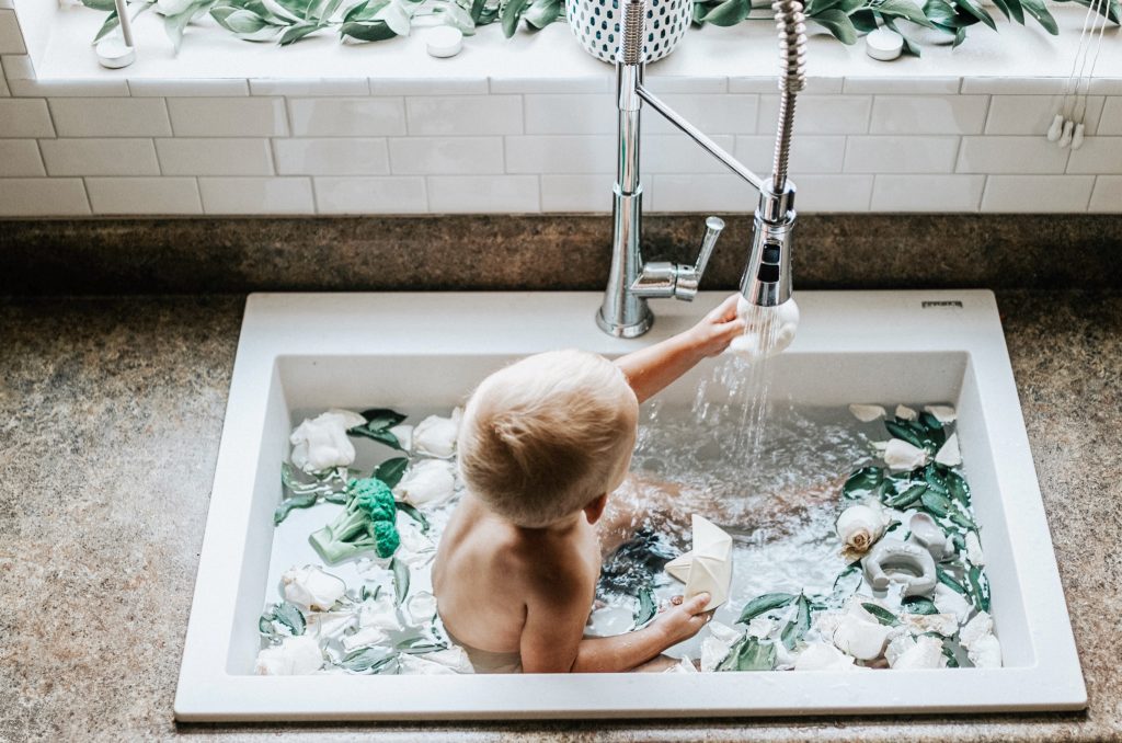 child bathing in sink. 
