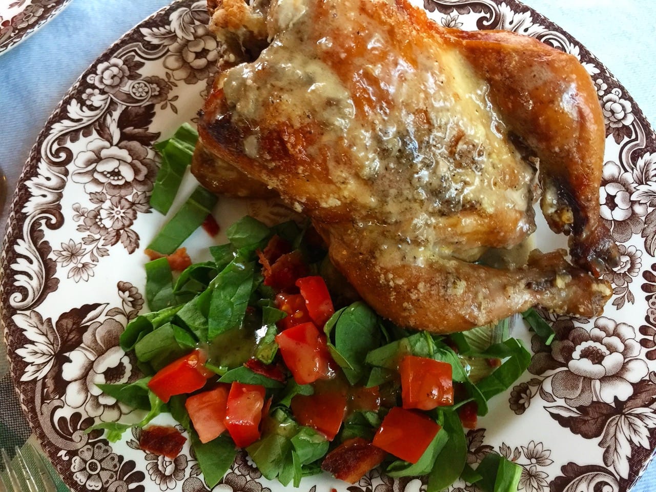 a fully cooked chicken with a salad on a plate