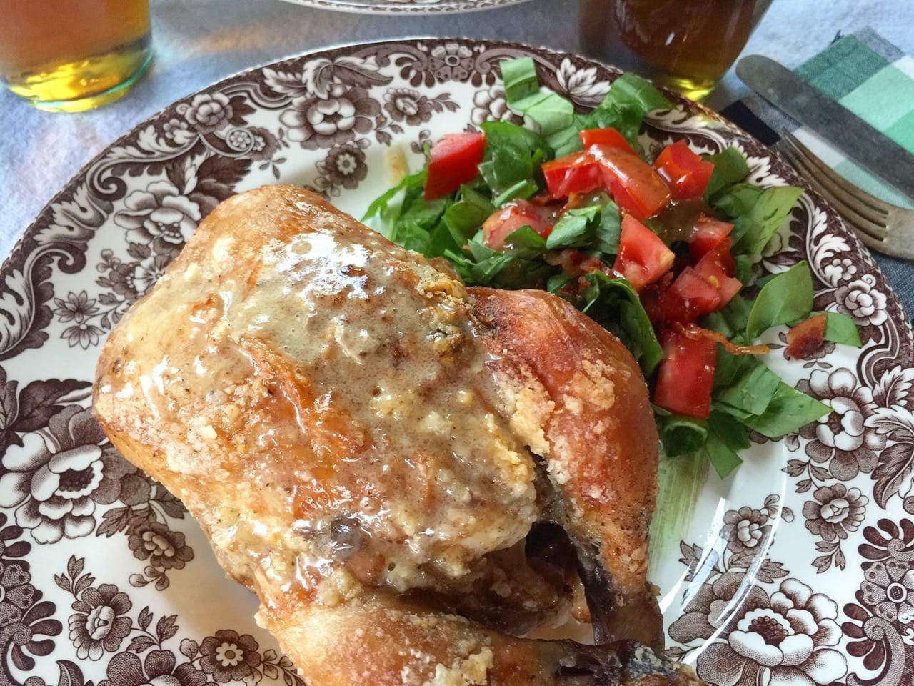 a cooked chicken on a plate with salad