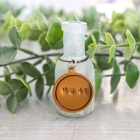 a copper key chain on a glass bottle