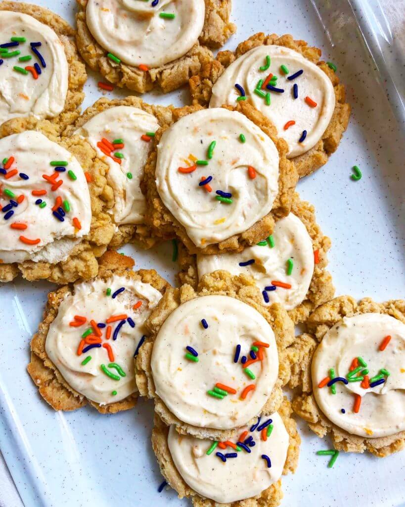 A tray of frosted cookies with colorful sprinkles.