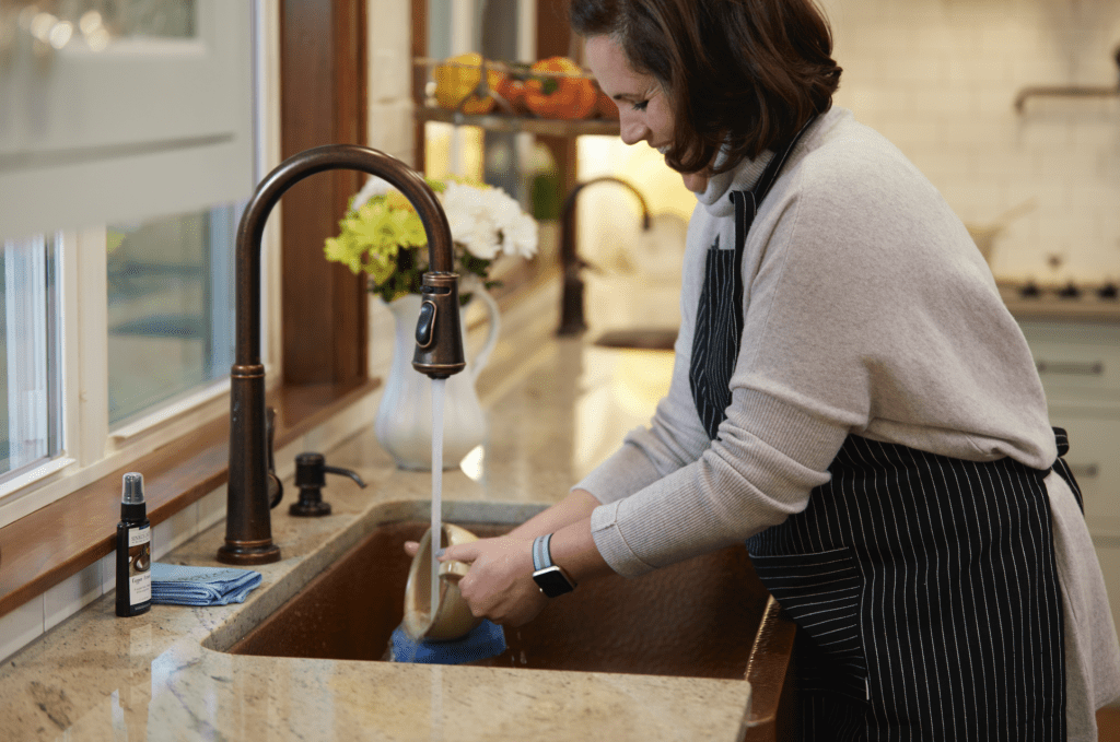 woman washing hands at copper sink