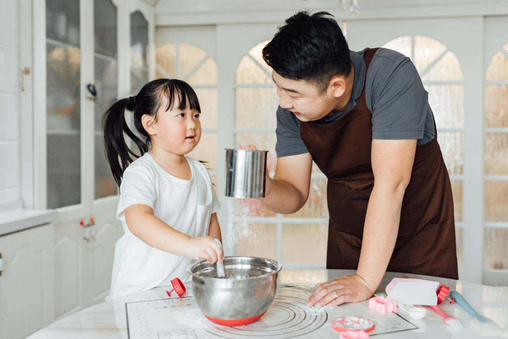 young family cooking in kitchen