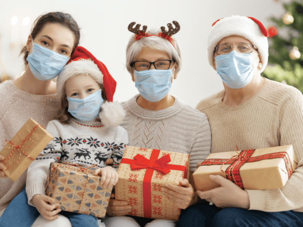 Family wearing masks while holding gifts