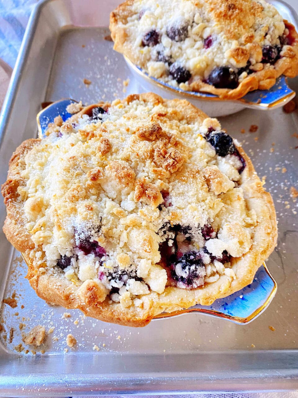 Two freshly baked blueberry crumble pies.