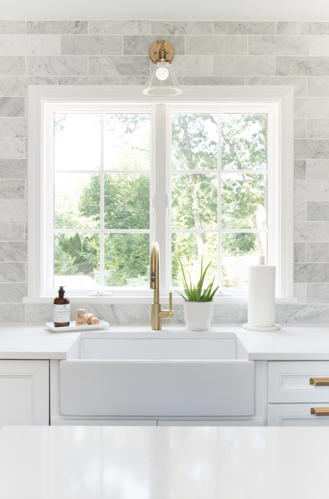 white fireclay sink in front of kitchen window