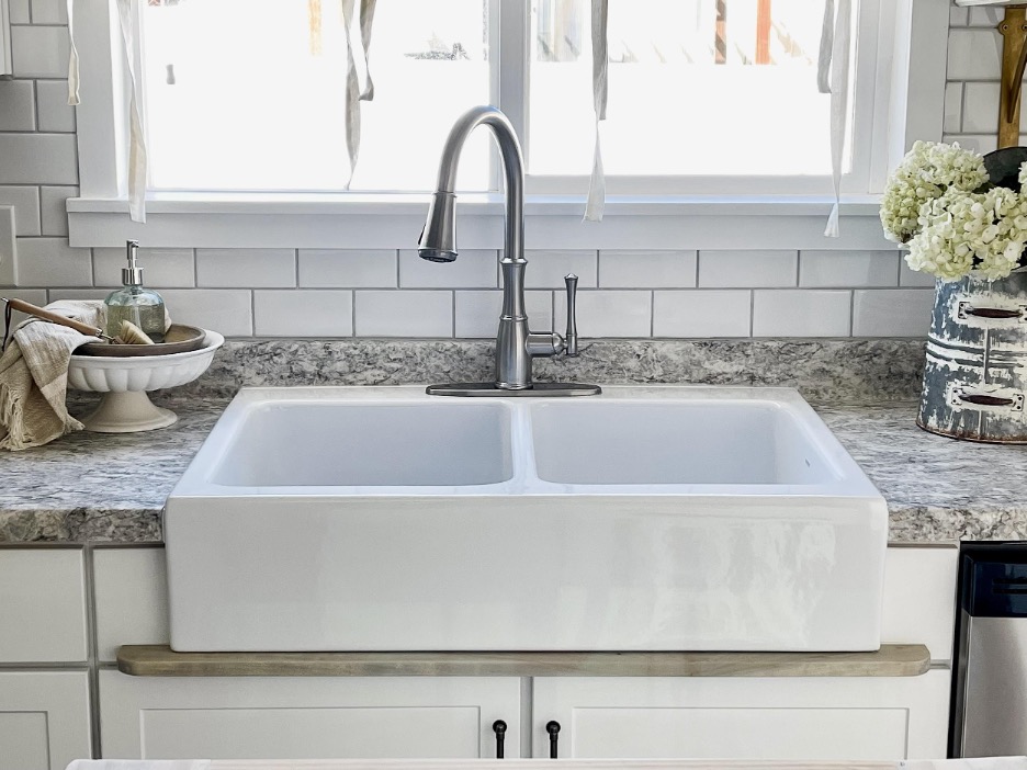 front view of newly installed fireclay sink sitting on a wooden drip edge.