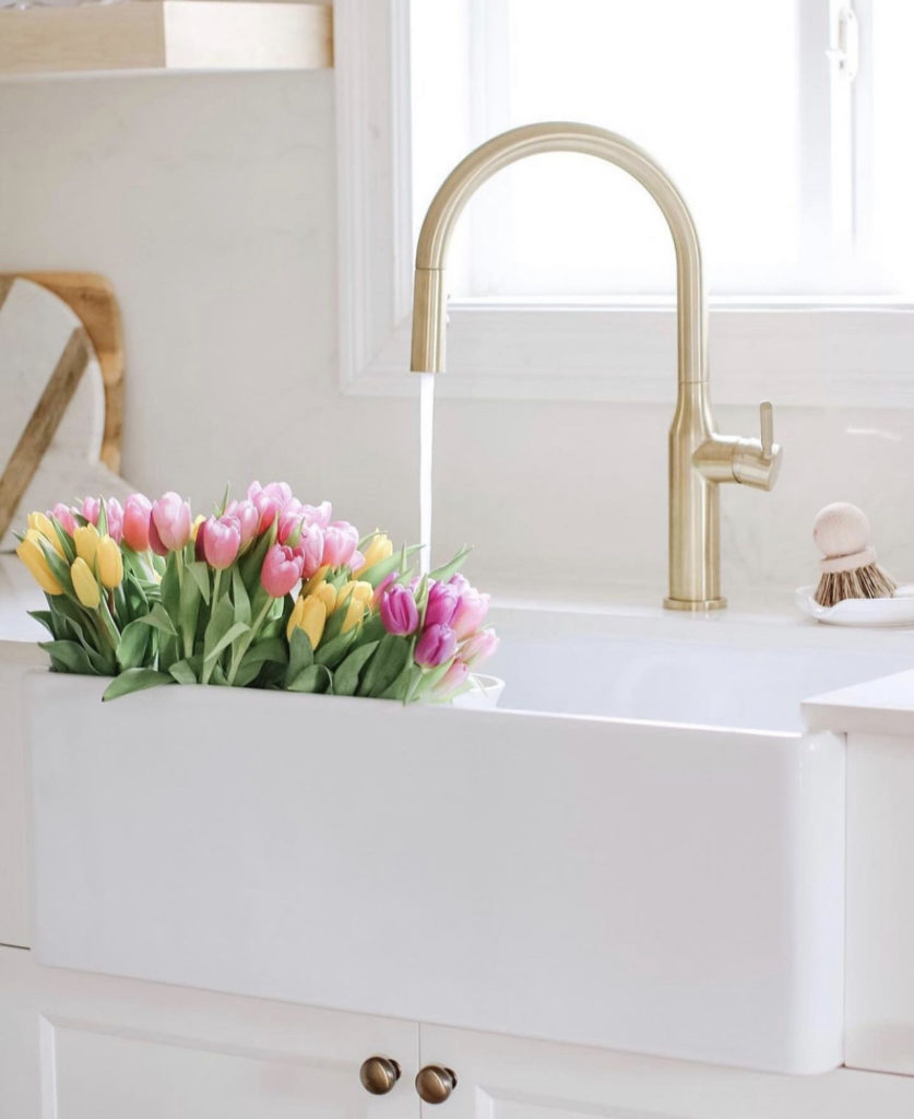 white sink with flowers and gold faucet