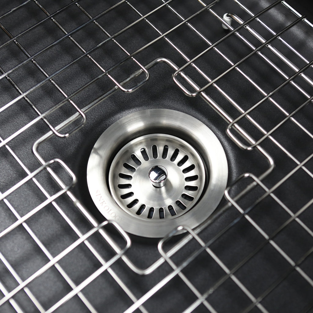 black sink with stainless steel drain and bottom grid