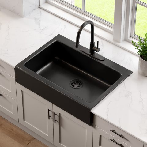 A matte black rectangular Quick-Fit® drop-in farmhouse sink made in fireclay with a modern black faucet, light gray countertops and white cabinets with a large window.