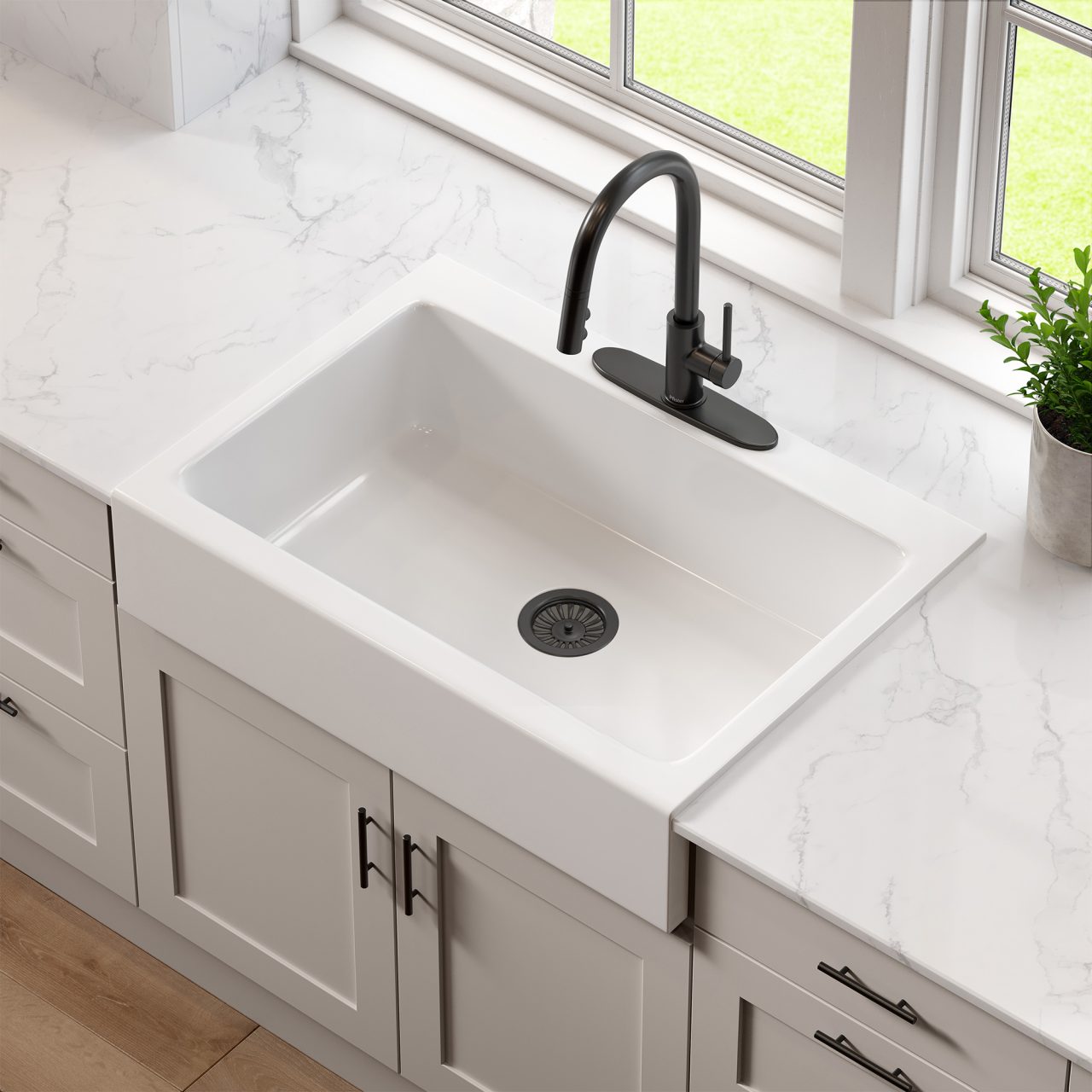 A glossy white rectangular Quick-Fit® drop-in farmhouse sink made in fireclay with a matte black faucet and drain set in a white marble countertop and light gray cabinets.