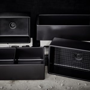 The Inspire Collection of matte black rectangular double bowl undermount farmhouse sinks made in fireclay with a 3.5" drain hole. Displayed in a group in an industrial setting.
