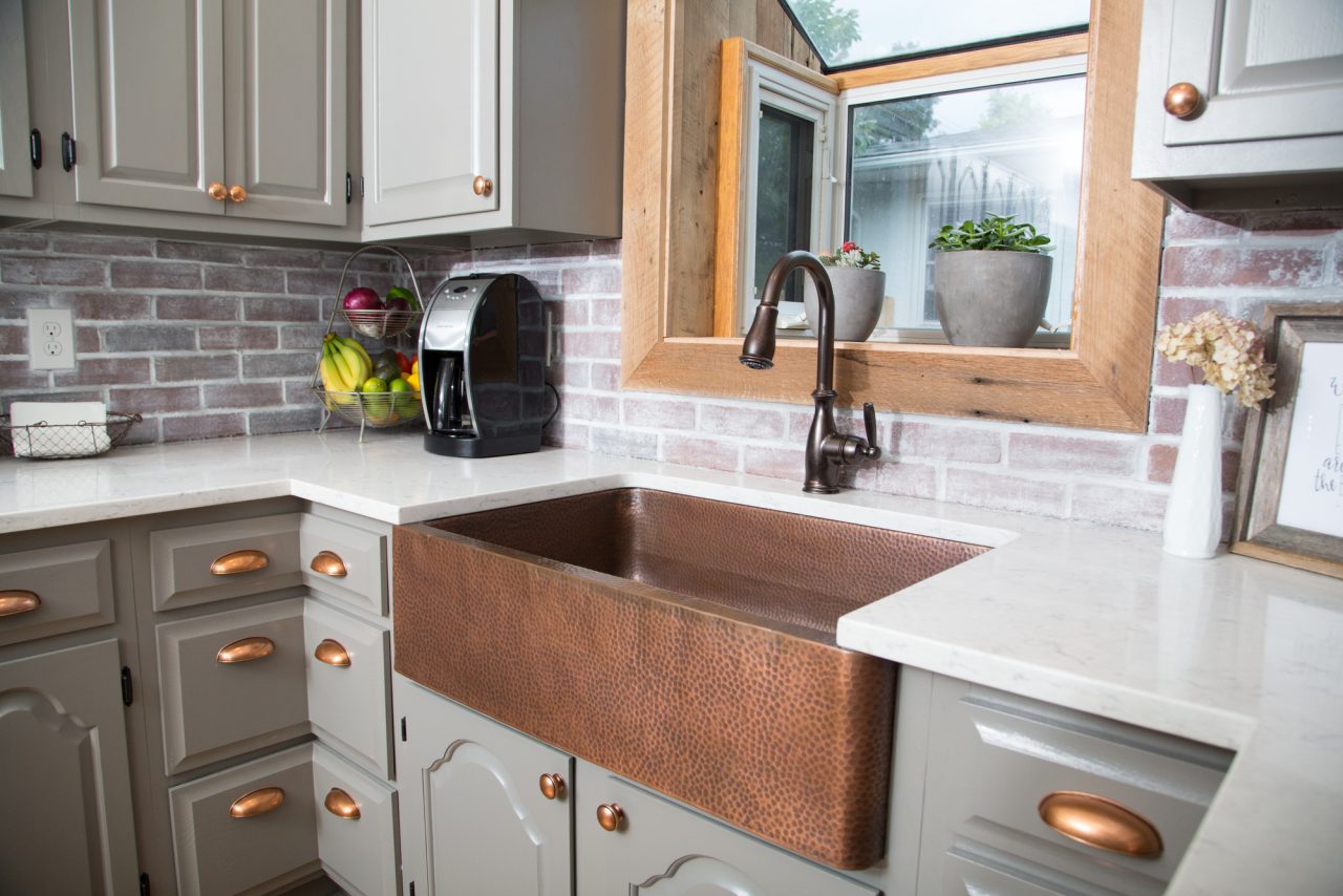 A copper rectangular undermount farmhouse sink in a clean modern farmhouse kitchen