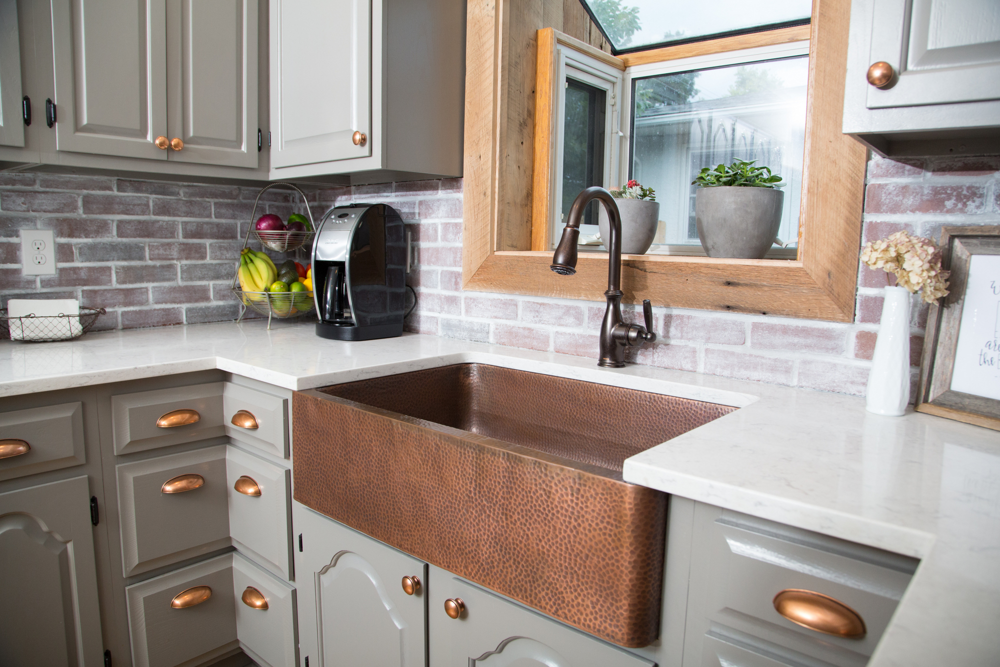 A copper rectangular undermount farmhouse sink in a clean modern farmhouse kitchen