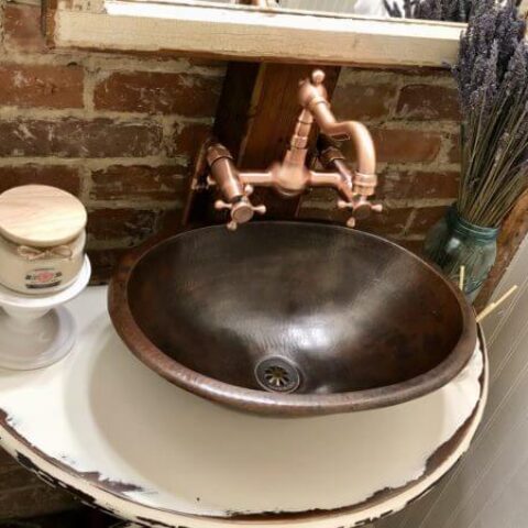 a copper bathroom sink with a copper faucet