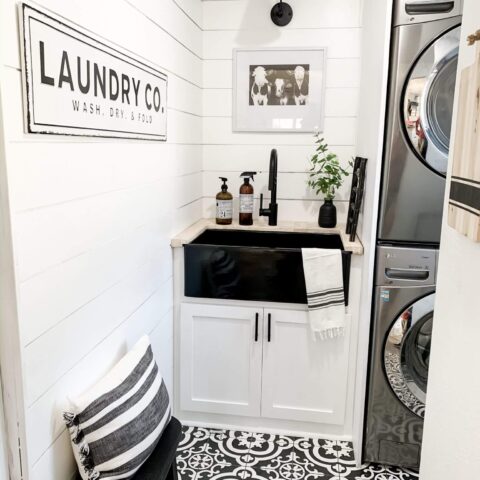 a glossy black fireclay sink in a laundry room