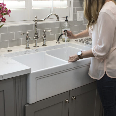 woman washing out her sink basin with pull down faucet