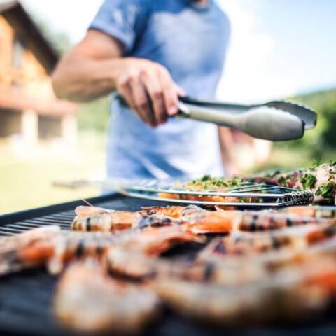 a man grilling meats on a bbq grill