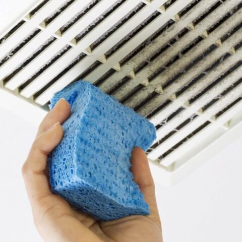 cleaning a vent with a blue sponge