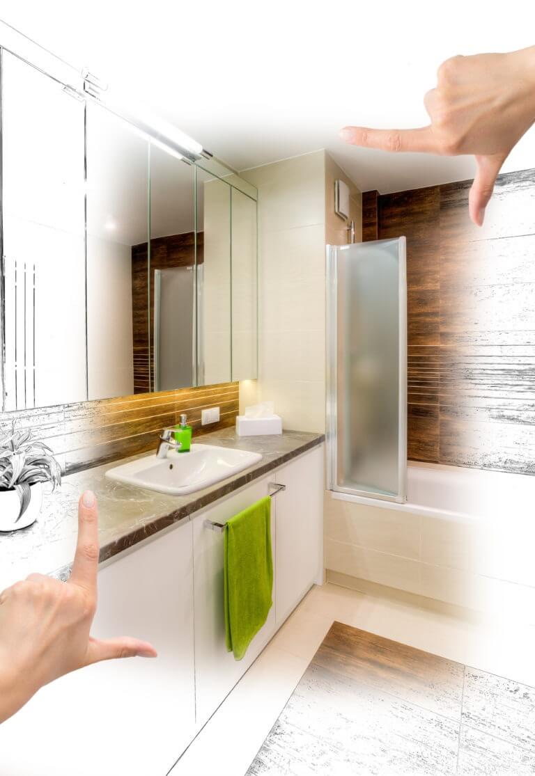 A bathroom sink with a green soap dispenser and towel, framed by hands indicating a design concept. A bathtub with a frosted glass screen is in the background.