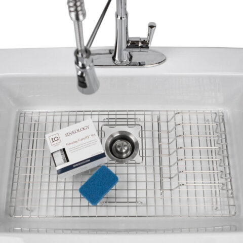 a fireclay sink with a bottom grid and other accessories