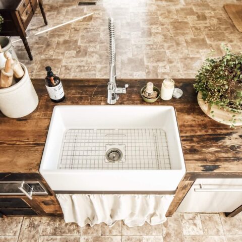 a white fireclay kitchen sink in a kitchen island
