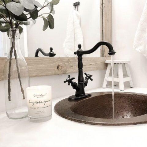 a copper bathroom sink with running faucet water