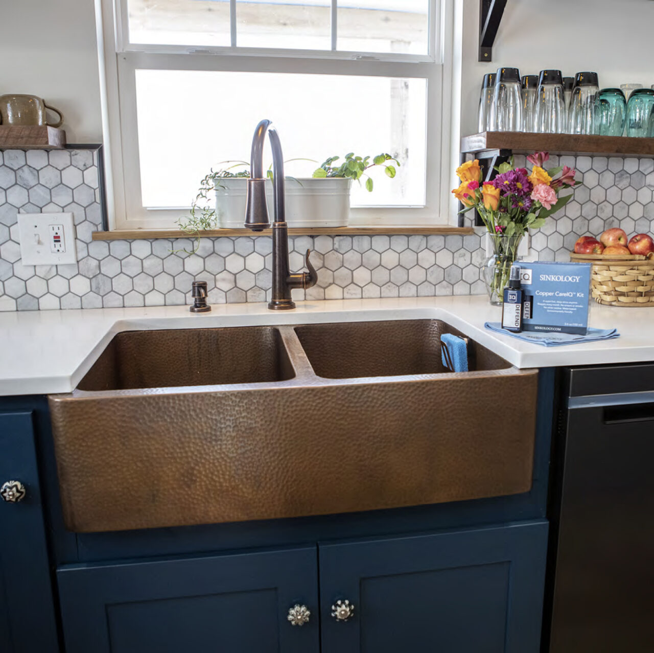 Kitchen with copper farmhouse sink and blue cabinets.