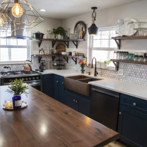 Kitchen with wood table, copper farmhouse sink and blue cabinets.