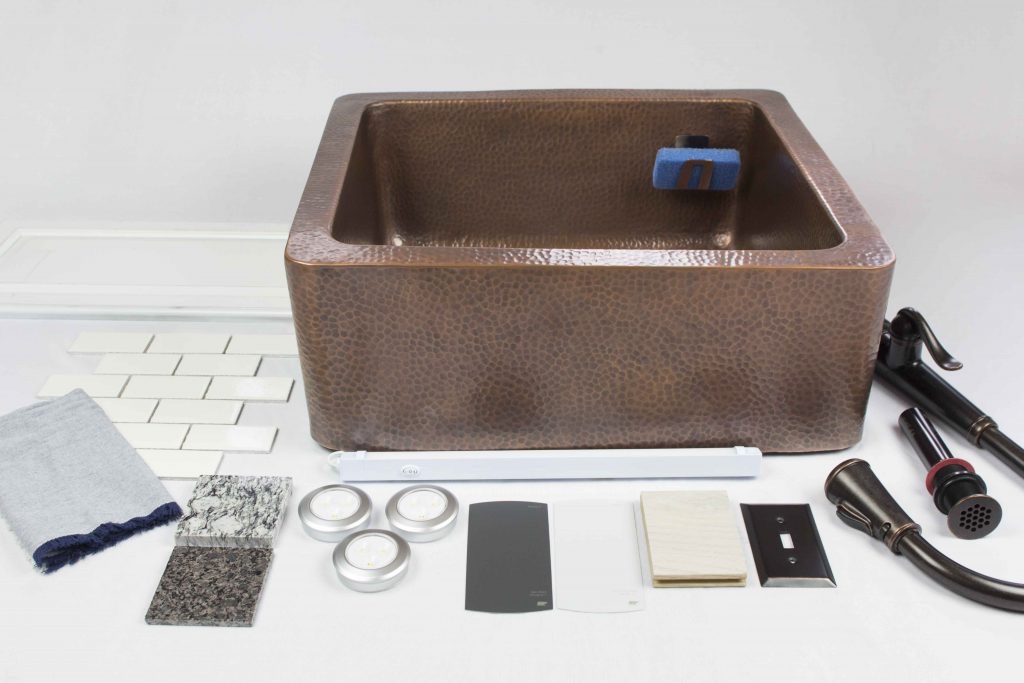 a copper farmhouse sink with kitchen decor and hardware laid out to show design