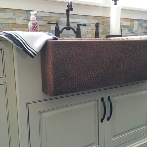 a copper kitchen sink and bronze faucet