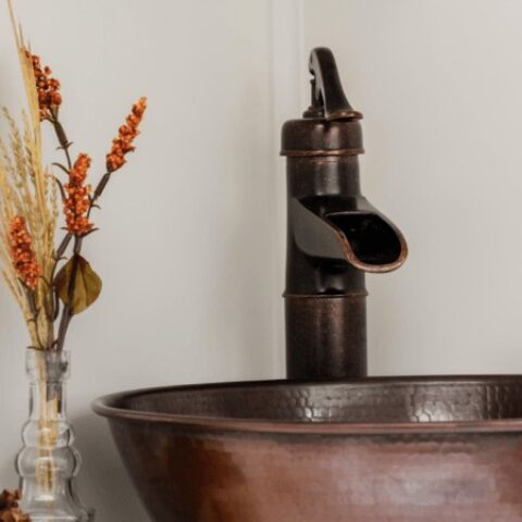 a copper vessel sink with matching faucet