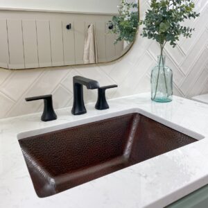 A hand hammered copper dual mount bathroom sink.