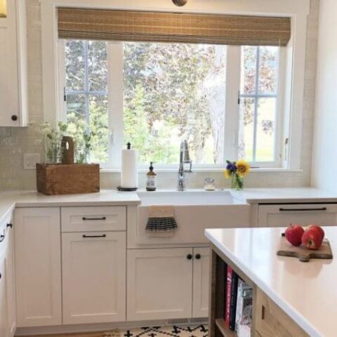 a white farmhouse kitchen with a fireclay sink