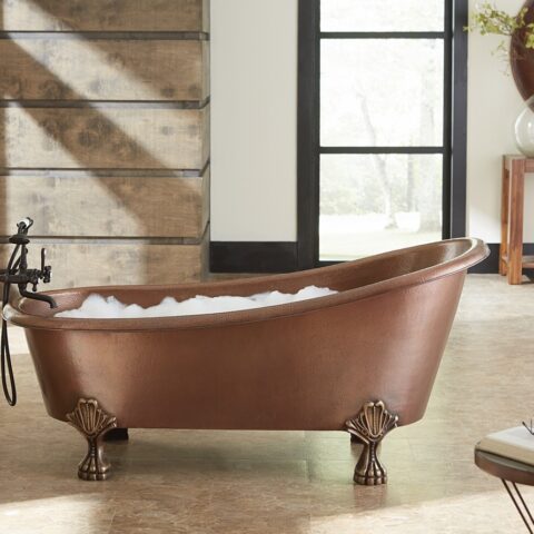 A hand hammered copper claw foot bath tub