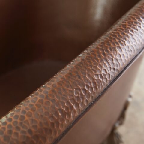 A hand hammered copper claw foot bath tub
