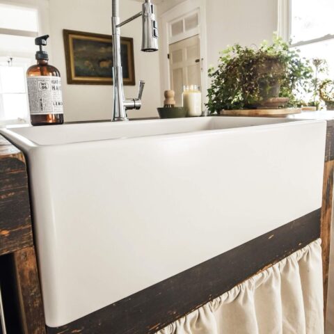 a white fireclay kitchen sink