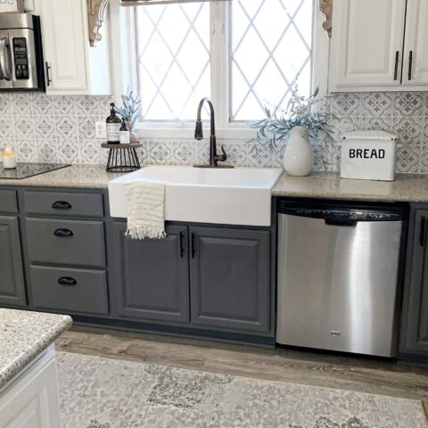 a white drop-in farmhouse fireclay kitchen sink in a kitchen with grayish blue cabinets