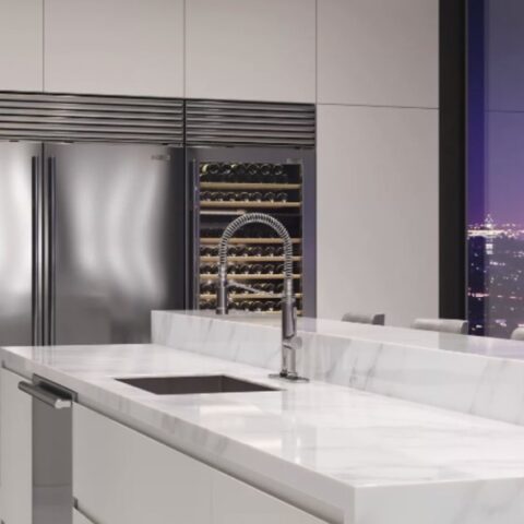 a chrome kitchen faucet in a modern looking sky rise kitchen