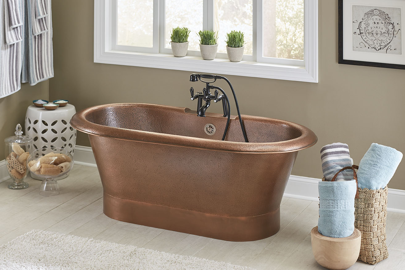 Freestanding copper bathtub in large open bathroom in front of window