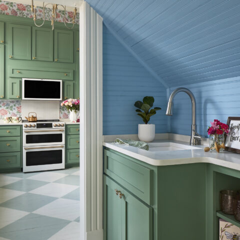 Brightly colored blue and green kitchen and prep area with a fireclay sink and stainless steel faucet