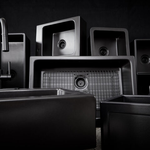 Family grouping of matte black fireclay sinks with faucets, drains and bottom grids to match.