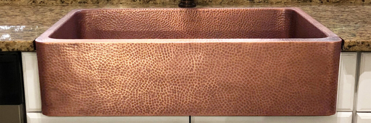 A detailed close up image of a copper kitchen sink.