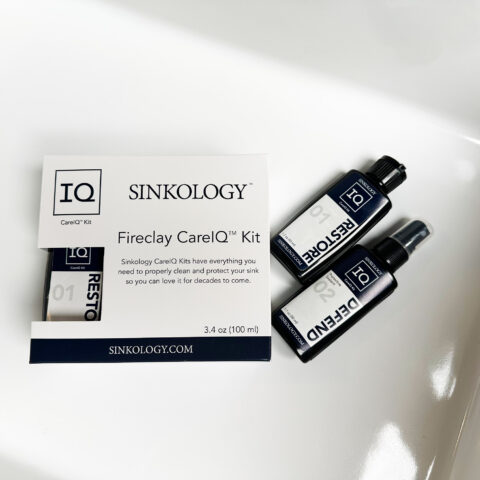 Sinkology Care IQ Kit laying in the bottom of a white fireclay kitchen sink