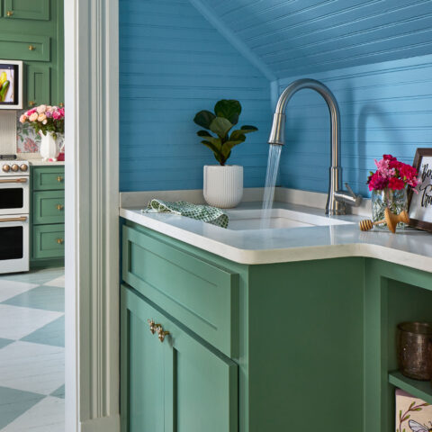 Brightly colored blue and green kitchen and prep area with a fireclay sink and stainless steel faucet