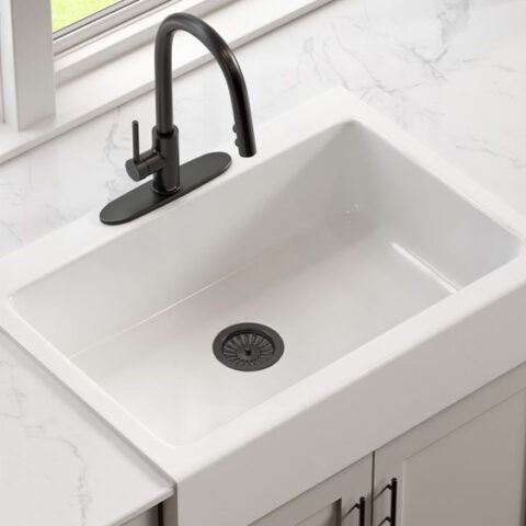 Modern white fireclay farmhouse quick-fit kitchen sink with black faucet and drain in white countertop and gray cabinets